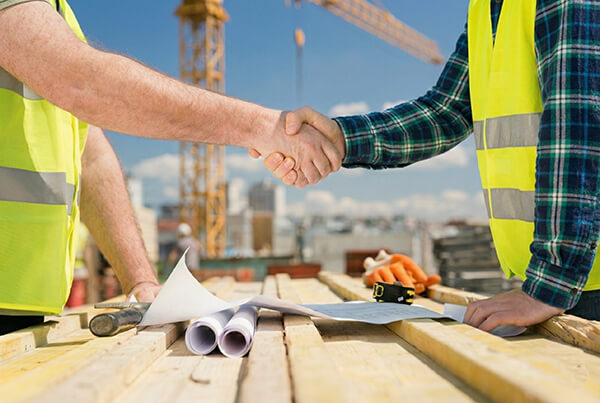 Construction workers shaking hands on construction